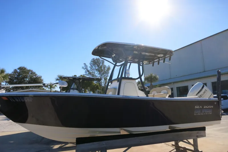 Slide: The Image of 2019 Sea Born LX22 Center Console boat under bright sun, parked outdoors. - 5