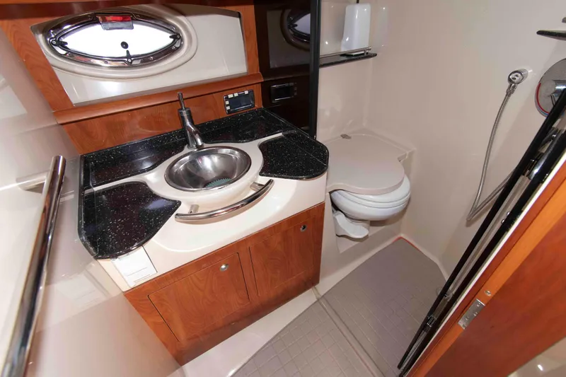 Slide: The Image of Luxurious 2007 Four Winns 358 Vista yacht bathroom with sink, toilet, and wood cabinetry. - 12