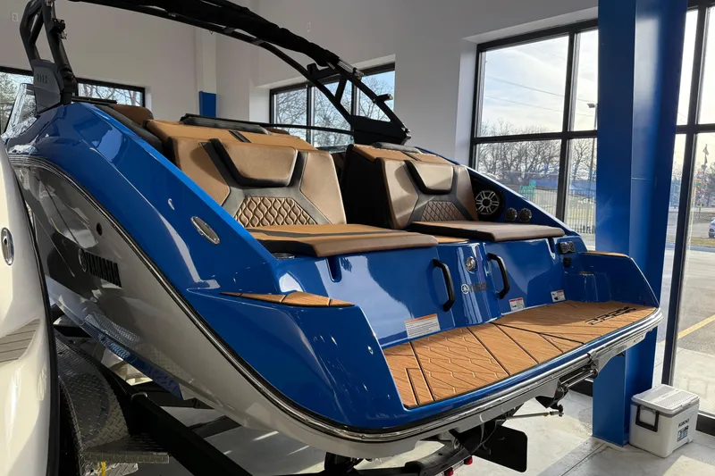 Slide: The Image of 2025 Yamaha Boats 222XE in showroom, featuring sleek blue design and comfortable seating. - 3