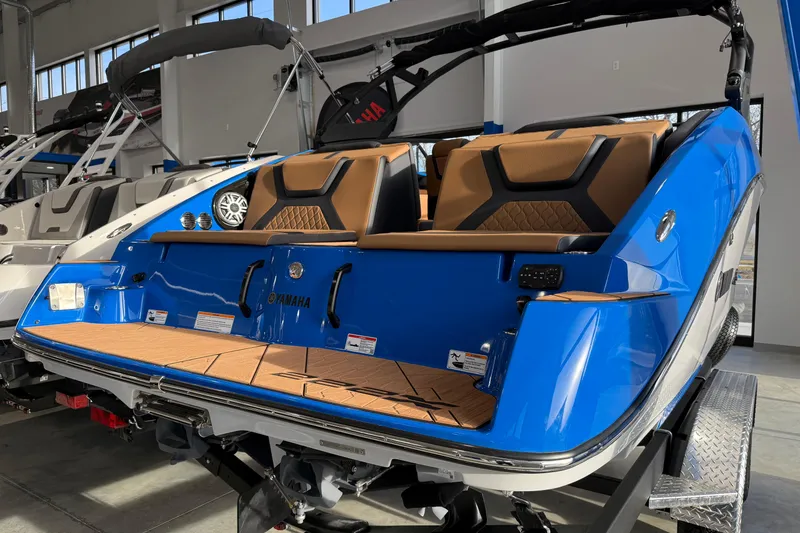 Slide: The Image of 2025 Yamaha Boats 222XE, blue exterior, luxury seating, displayed in showroom. - 4