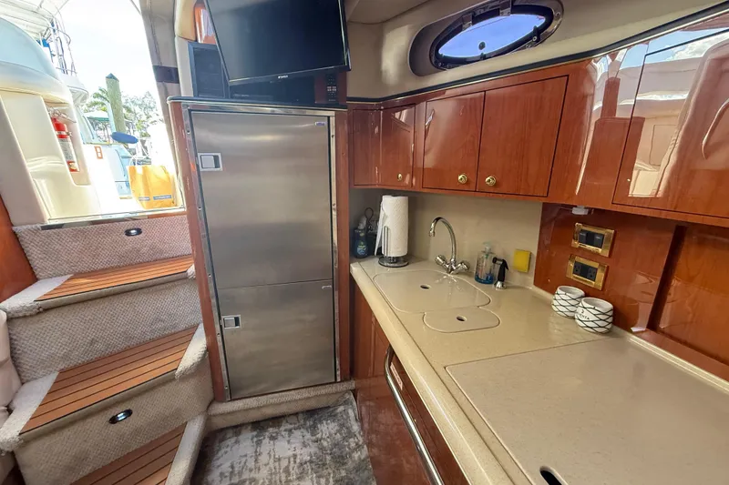Slide: The Image of Interior of 1999 Sea Ray 410 Express Cruiser with kitchenette and stairs. - 16