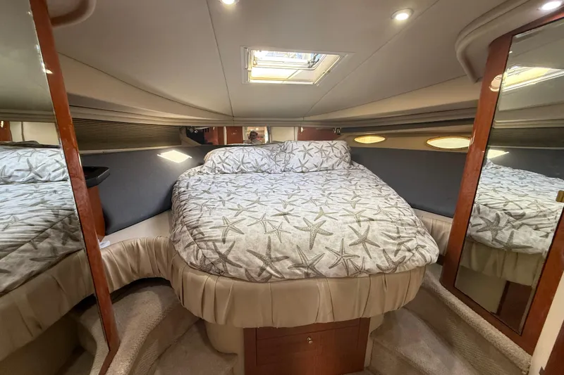 Slide: The Image of 1999 Sea Ray 410 Express Cruiser cabin with starfish-patterned bedding and mirrored walls. - 20