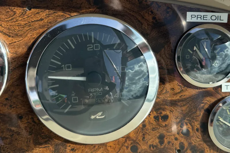 Slide: The Image of Close-up of 1999 Sea Ray 410 Express Cruiser dashboard gauges, featuring RPM and oil pressure indicators. - 24