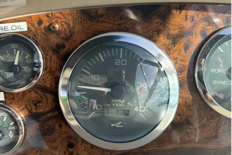 Slide: The Image of 1999 Sea Ray 410 Express Cruiser dashboard with RPM gauge and wood finish. - 28