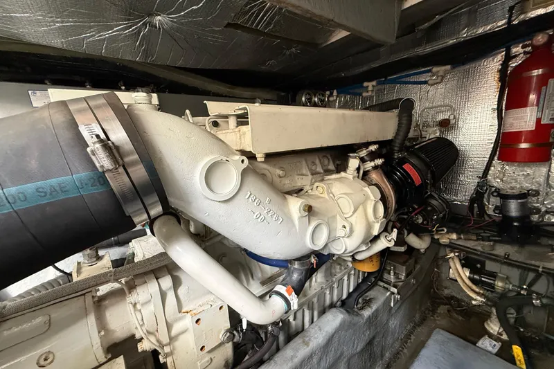 Slide: The Image of Engine room of 1999 Sea Ray 410 Express Cruiser with visible components and fire extinguisher. - 35