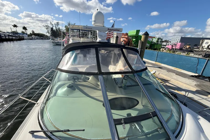 Slide: The Image of 1999 Sea Ray 410 Express Cruiser docked at marina under blue sky. - 4