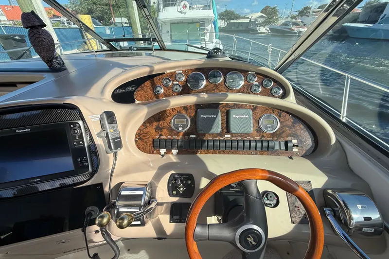 Slide: The Image of 1999 Sea Ray 410 Express Cruiser helm with wood accents and navigation equipment. - 7