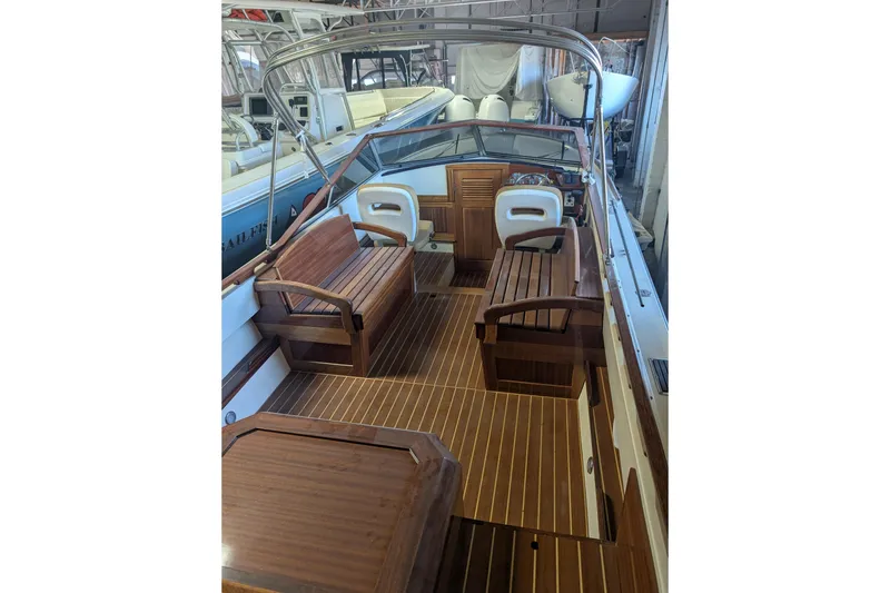 Slide: The Image of 1973 Lyman Islander boat interior with wooden seating and flooring in a showroom. - 10