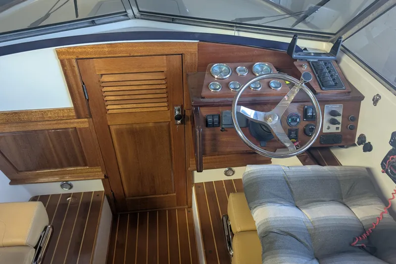 Slide: The Image of 1973 Lyman Islander boat interior with wooden dashboard and steering wheel. - 11