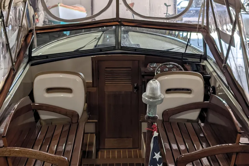 Slide: The Image of 1973 Lyman Islander boat interior with wooden seats and steering console. - 13