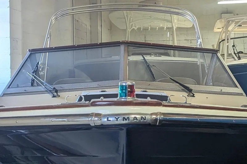 Slide: The Image of 1973 Lyman Islander boat in a garage, showcasing classic design and windshield details. - 14