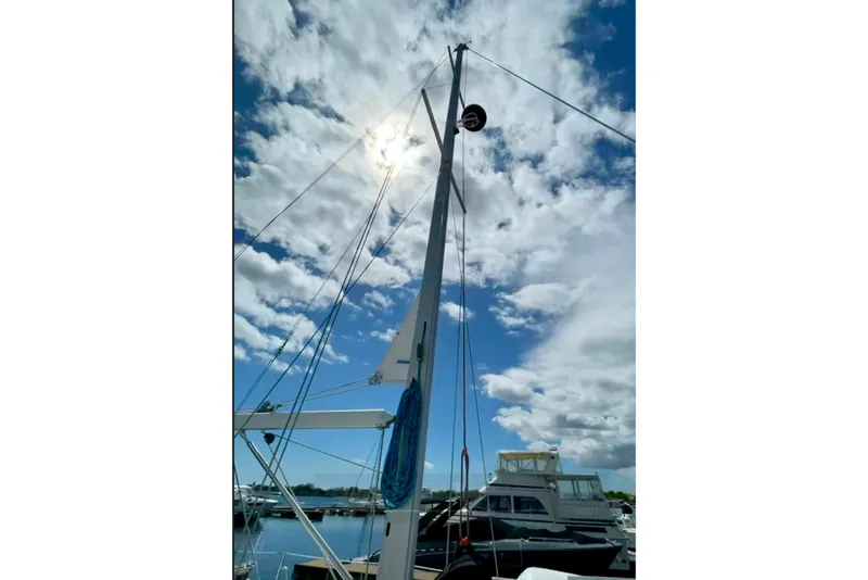 Slide: The Image of Mast of a 2004 Catalina 350 sailboat against a cloudy sky at a marina. - 14