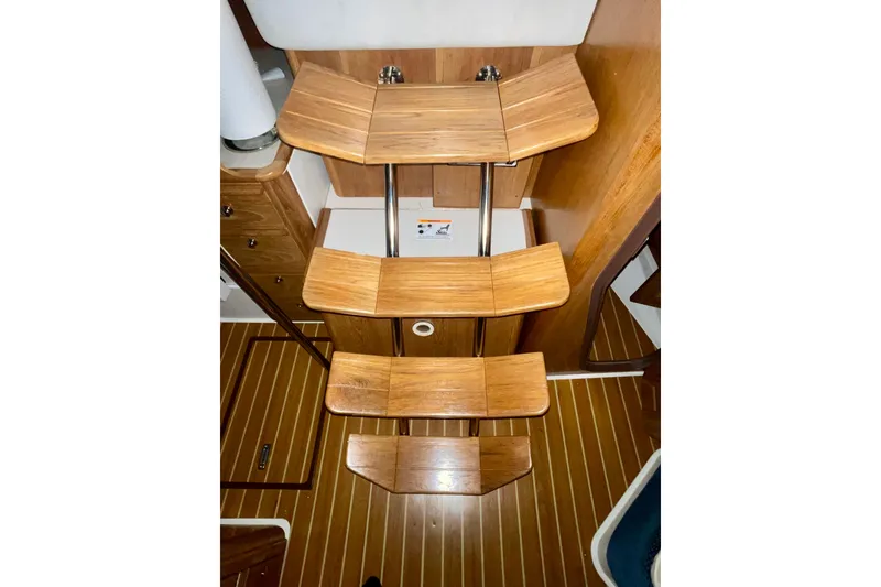 Slide: The Image of Wooden interior stairs of a 2004 Catalina 350 sailboat, featuring sleek design and craftsmanship. - 18