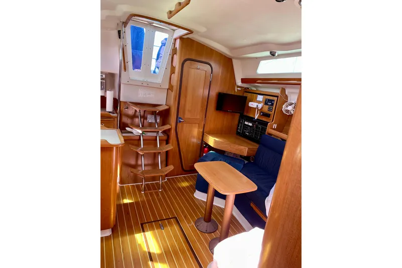 Slide: The Image of Interior of 2004 Catalina 350 sailboat with wooden furnishings and blue seating. - 19