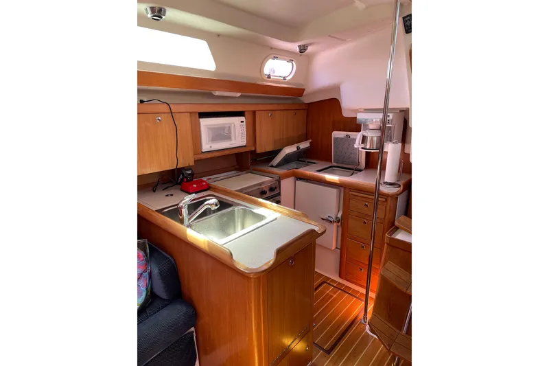 Slide: The Image of Interior of 2004 Catalina 350 sailboat kitchen with wooden cabinetry and modern appliances. - 20