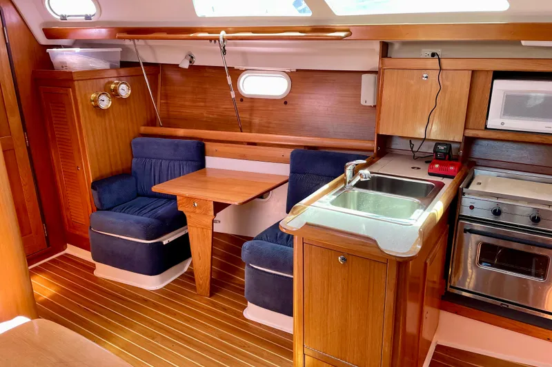 Slide: The Image of Interior of 2004 Catalina 350 sailboat with kitchen and seating area. - 21