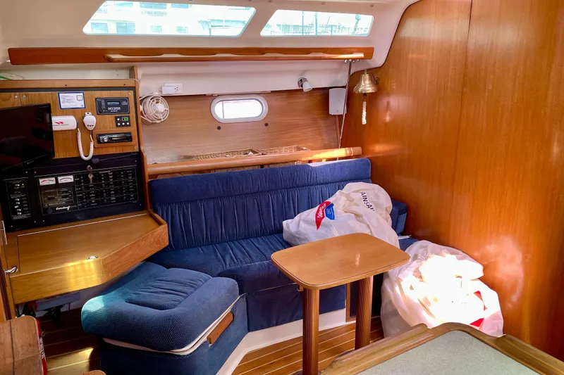 Slide: The Image of Interior of a 2004 Catalina 350 sailboat with blue seating and wooden accents. - 22