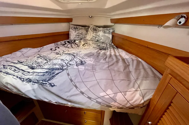 Slide: The Image of Cozy cabin interior of 2004 Catalina 350 sailboat with nautical-themed bedding. - 23