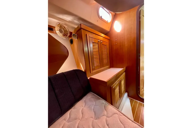 Slide: The Image of Interior of 2004 Catalina 350 sailboat with wooden cabinetry and cozy sleeping area. - 28
