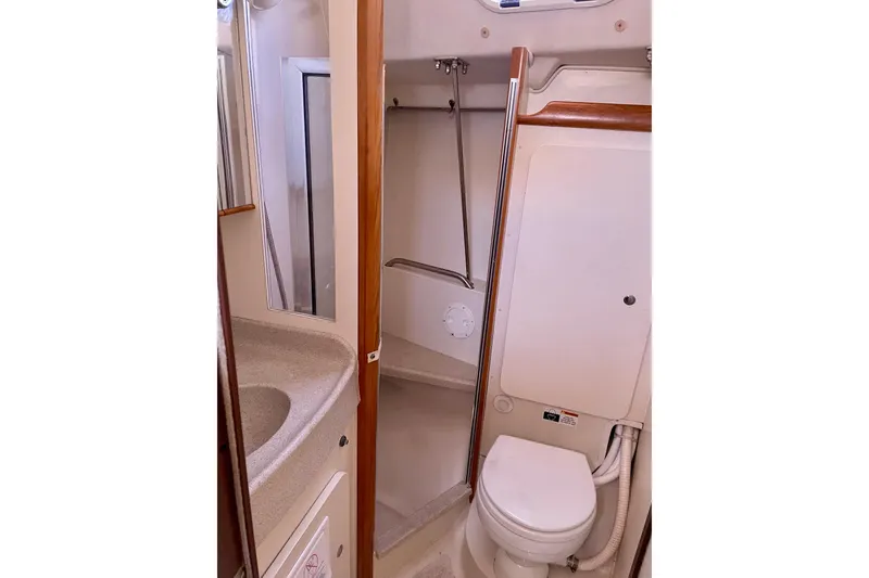 Slide: The Image of Bathroom interior of a 2004 Catalina 350 yacht, featuring a compact toilet and sink. - 30