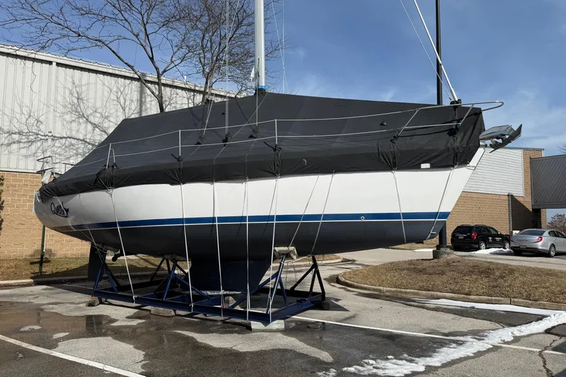 Slide: The Image of 2004 Catalina 350 sailboat on stands, covered, in a parking lot. - 33