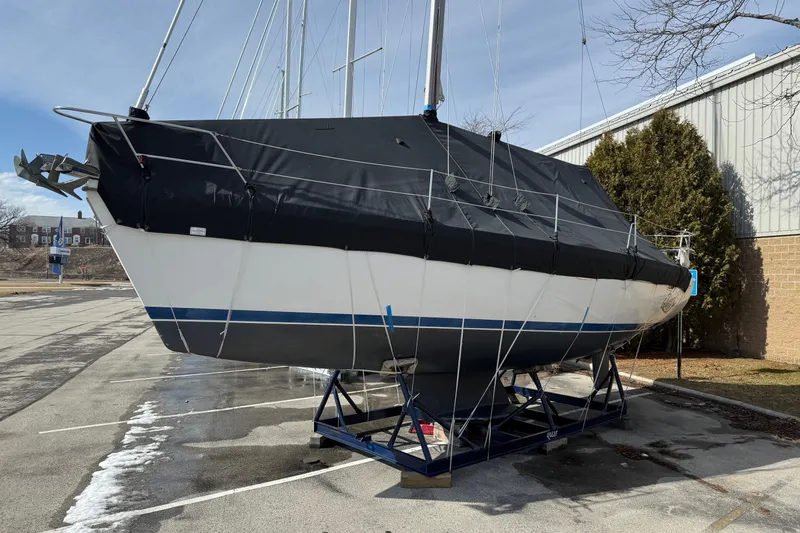 Slide: The Image of 2004 Catalina 350 sailboat on a stand, covered, in a parking lot. - 34