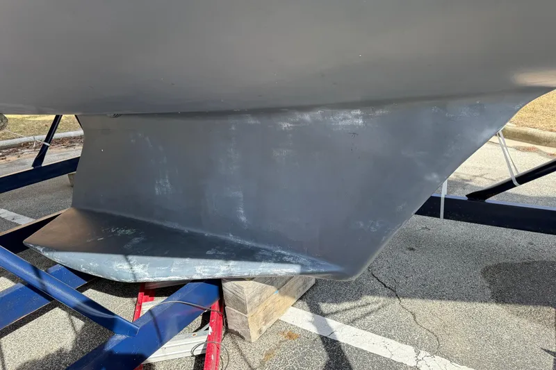 Slide: The Image of 2004 Catalina 350 sailboat keel on a trailer in a parking lot. - 36