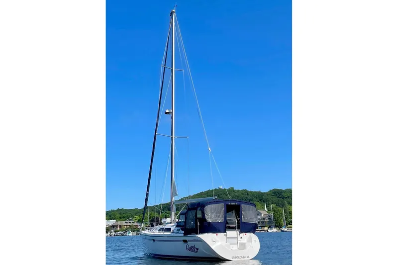 Slide: The Image of 2004 Catalina 350 sailboat on calm water with clear blue sky background. - 4