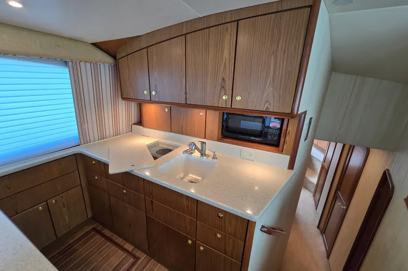 Slide: The Image of Luxurious kitchen interior of 2007 Ocean Yachts 46 Super Sport with wood cabinetry and modern appliances. - 21