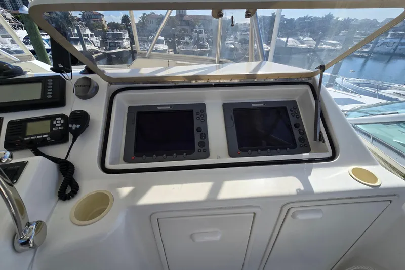 Slide: The Image of Control panel of a 2007 Ocean Yachts 46 Super Sport with navigation screens and communication devices. - 46