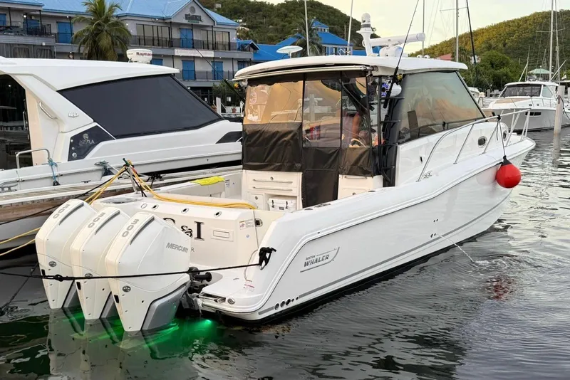 The Image of 2023 Boston Whaler 345 Conquest boat docked with triple Mercury engines. - 1