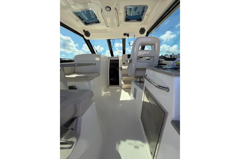 Slide: The Image of Interior of 2023 Boston Whaler 345 Conquest boat, featuring modern seating and helm. - 12