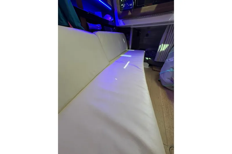 Slide: The Image of Interior of 2023 Boston Whaler 345 Conquest with white seating and ambient lighting. - 18