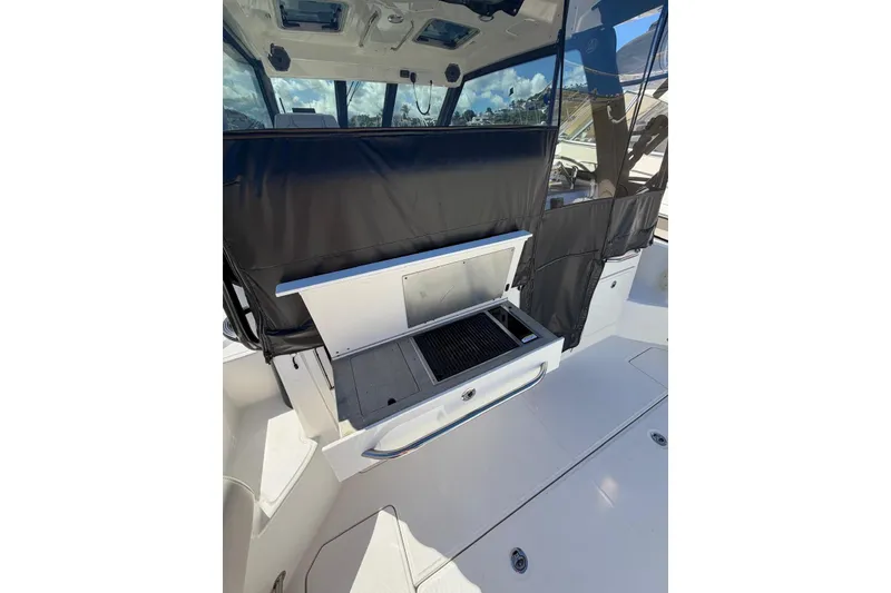 Slide: The Image of 2023 Boston Whaler 345 Conquest boat with outdoor grill and seating area. - 9