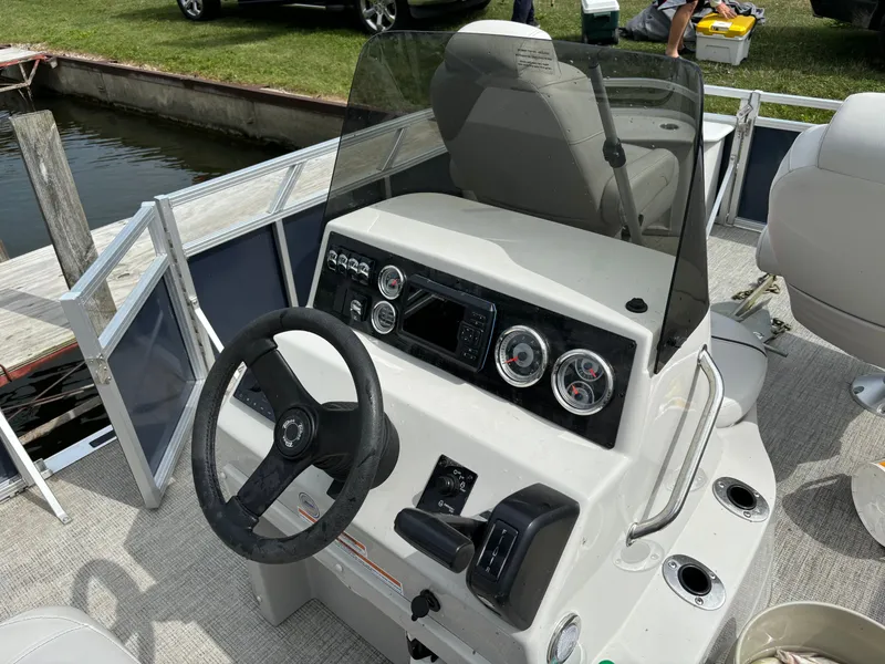 Slide: The Image of 2022 Tahoe GT 2585 CCF Tritoon boat helm at dock. - 14