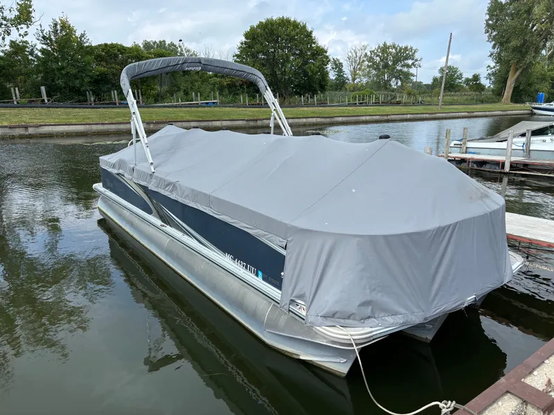 Slide: The Image of 2022 Tahoe GT 2585 CCF Tritoon with cover on water. - 3