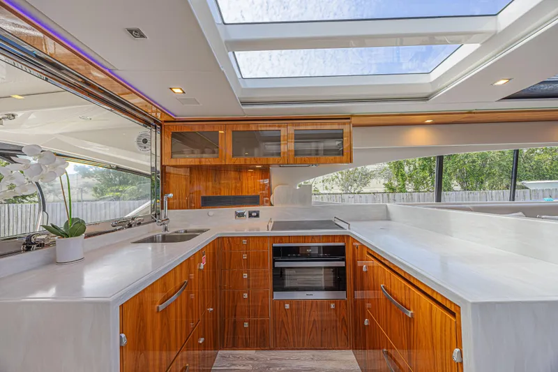 Slide: The Image of Luxurious kitchen interior of 2021 Riviera 6000 Sport Yacht Platinum Edition with skylight and modern amenities. - 27
