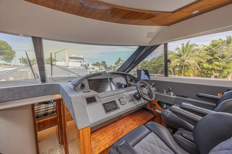 Slide: The Image of Luxurious 2021 Riviera 6000 Sport Yacht Platinum Edition helm with modern controls and leather seating. - 35