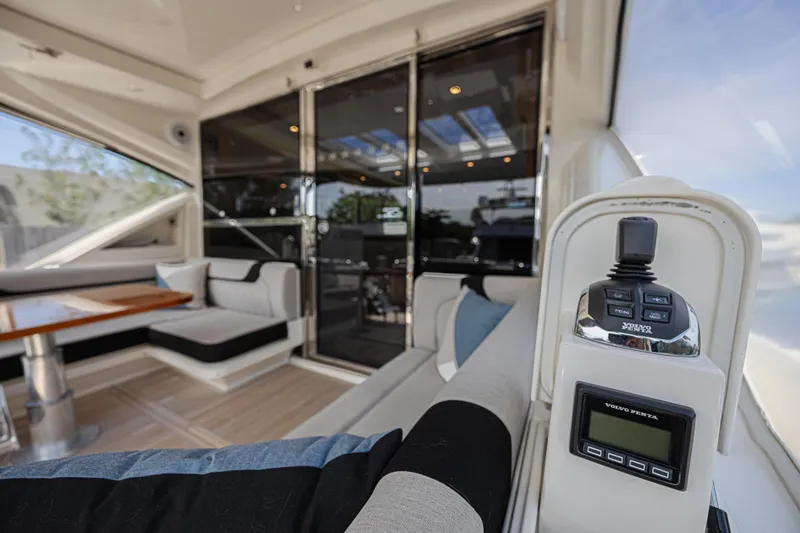 Slide: The Image of Interior of 2021 Riviera 6000 Sport Yacht Platinum Edition, featuring luxurious seating and control panel. - 8