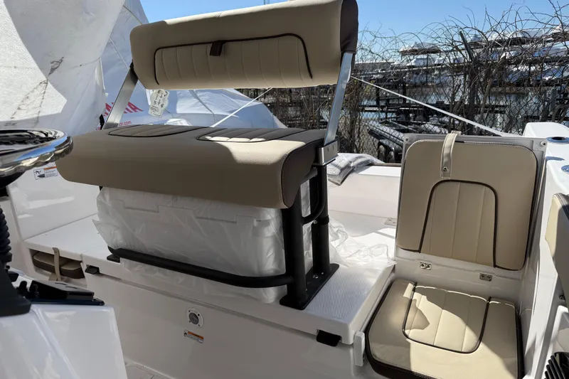 Slide: The Image of 2025 Yamaha Boats 222 FSH Sport E interior seating with beige upholstery and storage. - 4
