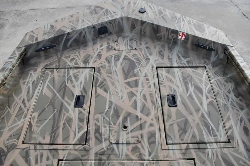 Slide: The Image of 2026 Lowe Roughneck RX1860 Tunnel Jet boat with camouflage pattern and storage compartments. - 15