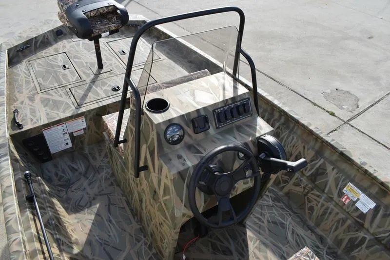 Slide: The Image of 2026 Lowe Roughneck RX1860 Tunnel Jet boat interior with camouflage design and steering console. - 24