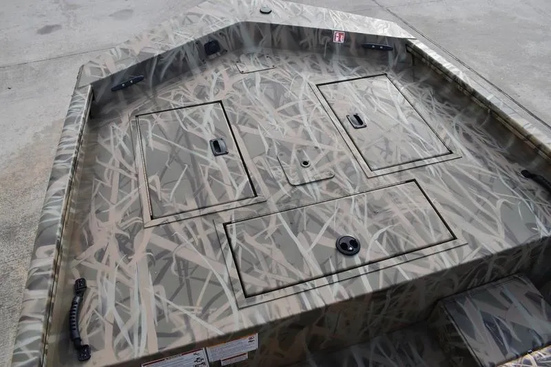 Slide: The Image of 2026 Lowe Roughneck RX1860 Tunnel Jet boat with camouflage pattern and storage compartments. - 7