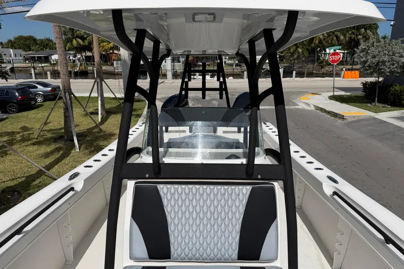 Slide: The Image of 2021 Twin Vee 310 CC GF boat interior with seating and console, parked on a street. - 10