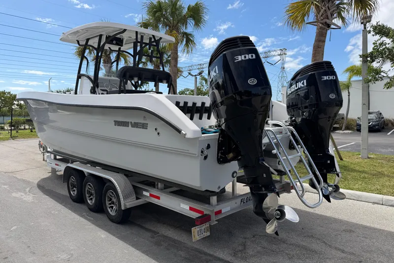 Slide: The Image of 2021 Twin Vee 310 CC GF boat on trailer with dual Suzuki 300 engines. - 2