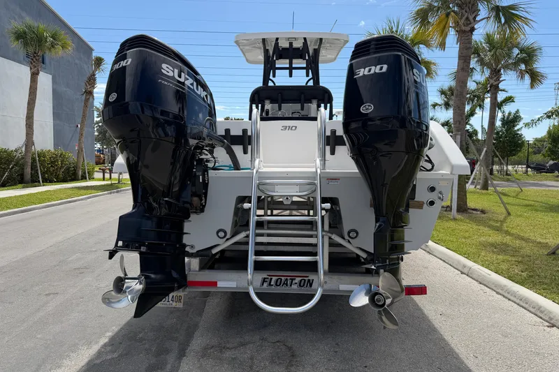 Slide: The Image of 2021 Twin Vee 310 CC GF boat with dual Suzuki 300 engines on a trailer. - 3