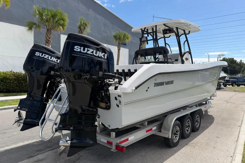 Slide: The Image of 2021 Twin Vee 310 CC GF boat with dual Suzuki engines on a trailer. - 4