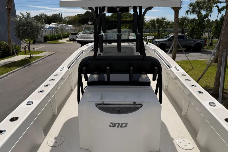 Slide: The Image of 2021 Twin Vee 310 CC GF boat interior with seating and console, parked outdoors. - 5
