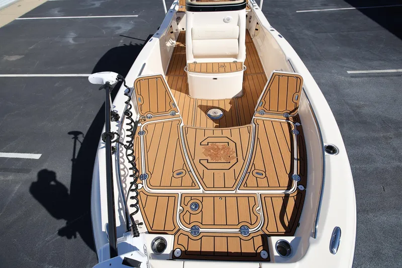 Slide: The Image of 2024 Grady-White 251 Coastal Explorer boat with teak deck, parked on asphalt. - 22