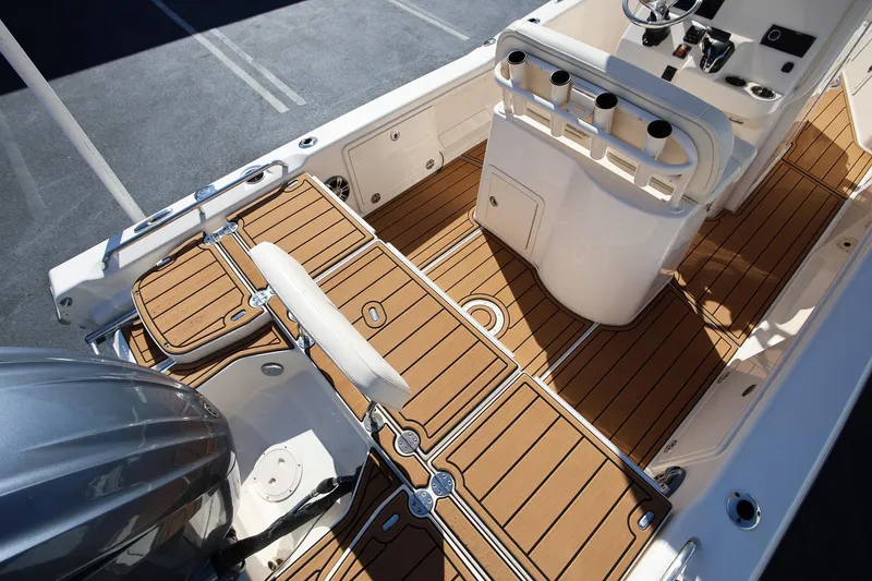 Slide: The Image of 2024 Grady-White 251 Coastal Explorer boat interior with teak flooring and helm station. - 6